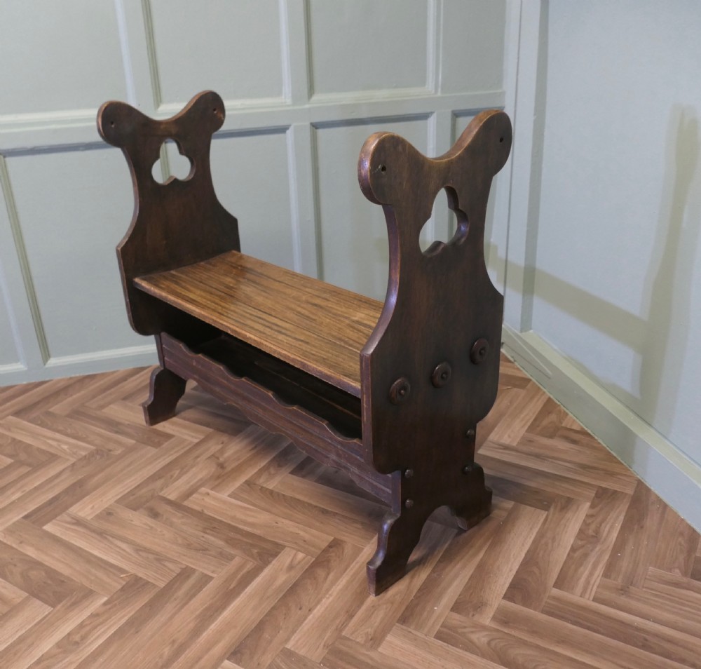 A dark walnut hall bench with high cutout side supports, a flat wooden seat, and a lower scalloped shelf for shoe storage. View III