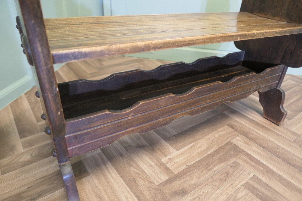 A dark walnut hall bench with high cutout side supports, a flat wooden seat, and a lower scalloped shelf for shoe storage. View VI