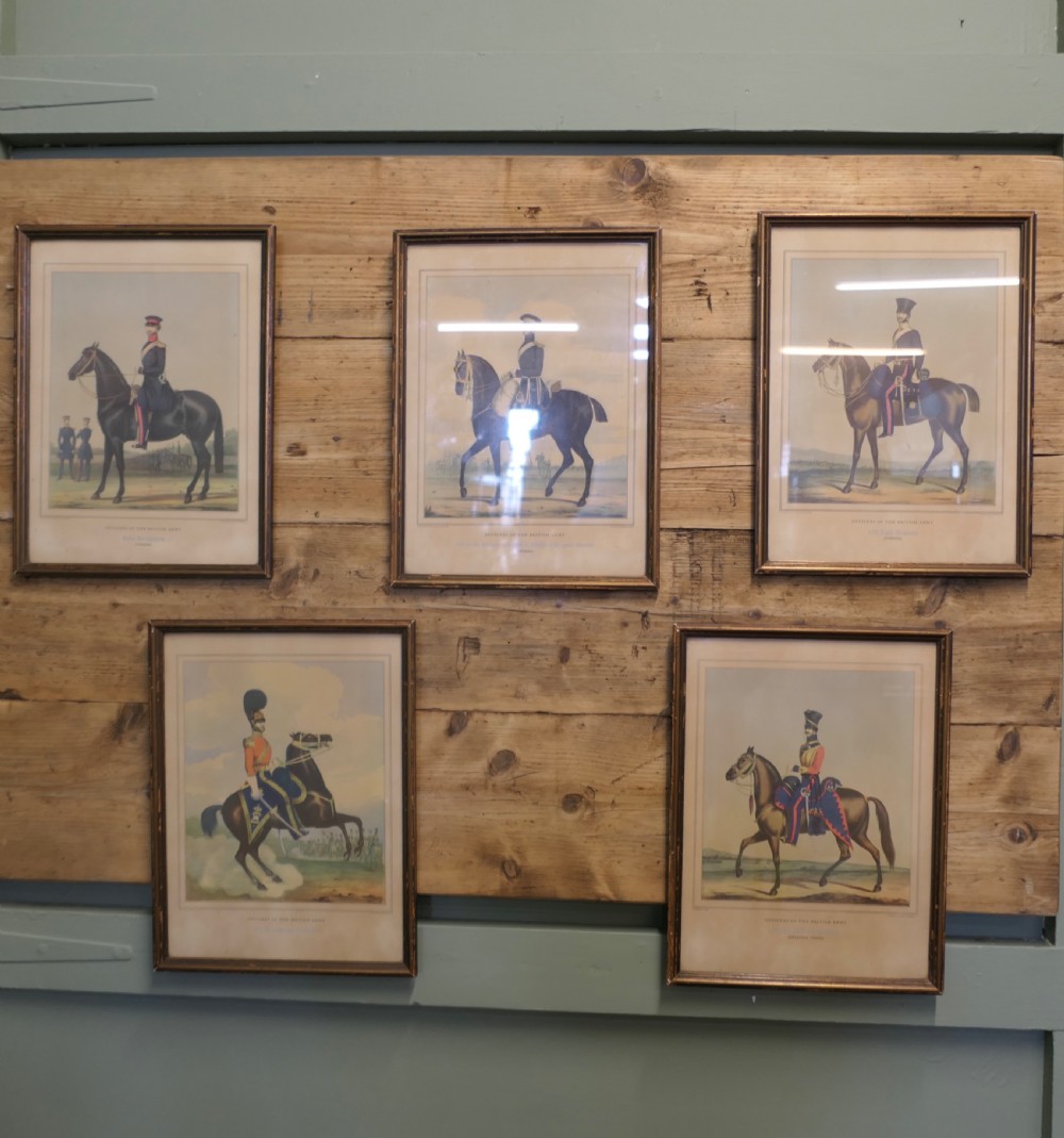 A set of five framed antique prints depicting British Army cavalry officers in uniform mounted on horses.