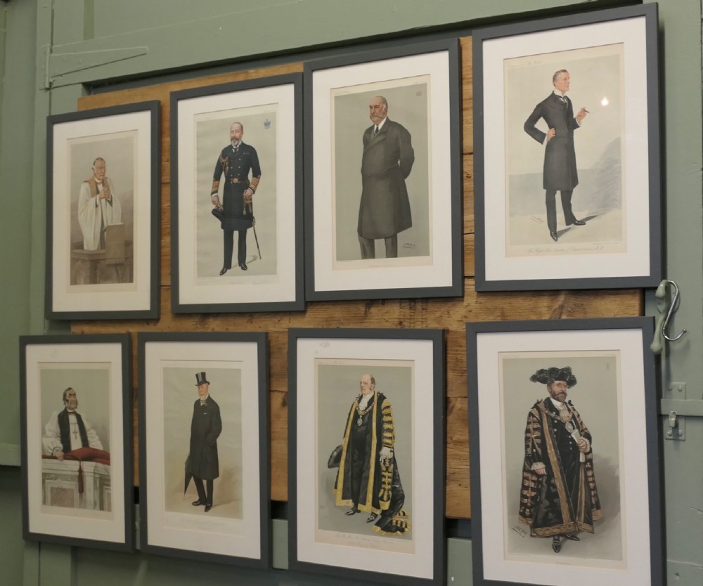 A collection of eight framed Vanity Fair caricature prints depicting Victorian and Edwardian figures displayed in matching dark frames.