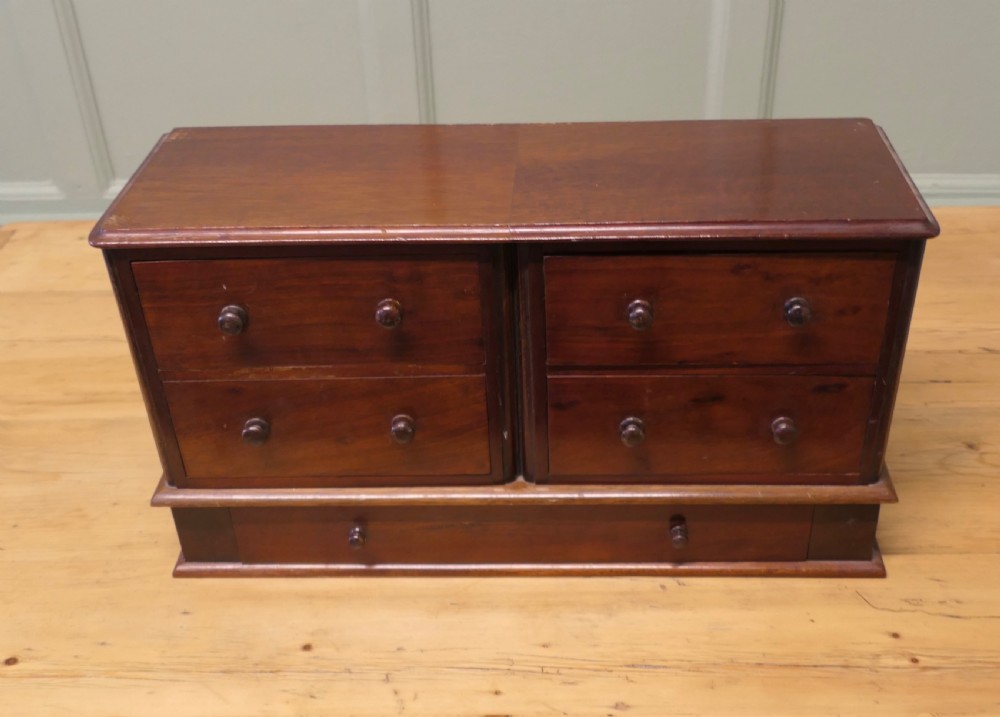 A mahogany desktop cabinet featuring five drawers with turned wooden handles arranged in two upper rows and one lower wide drawer. View II