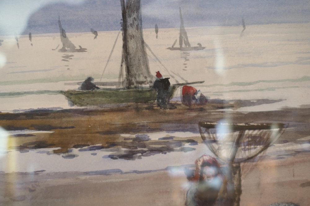 A framed coastal watercolour painting featuring figures on a shore with fishing boats in the distance beneath a cloudy blue sky. View V