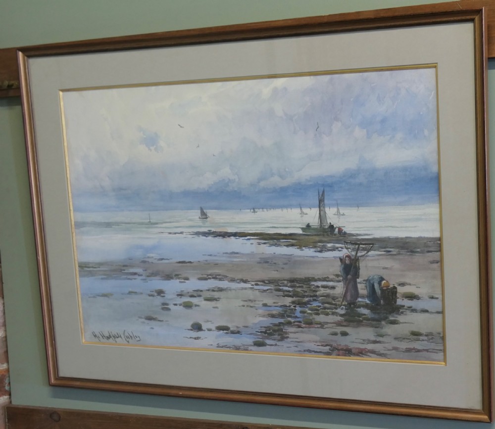 A framed coastal watercolour painting featuring figures on a shore with fishing boats in the distance beneath a cloudy blue sky. View VI