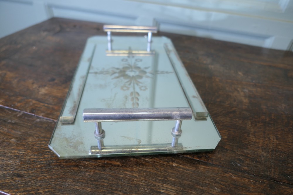 A rectangular Art Deco mirrored tray featuring central etched floral details, cut corners, and tubular silver-tone handles. View III
