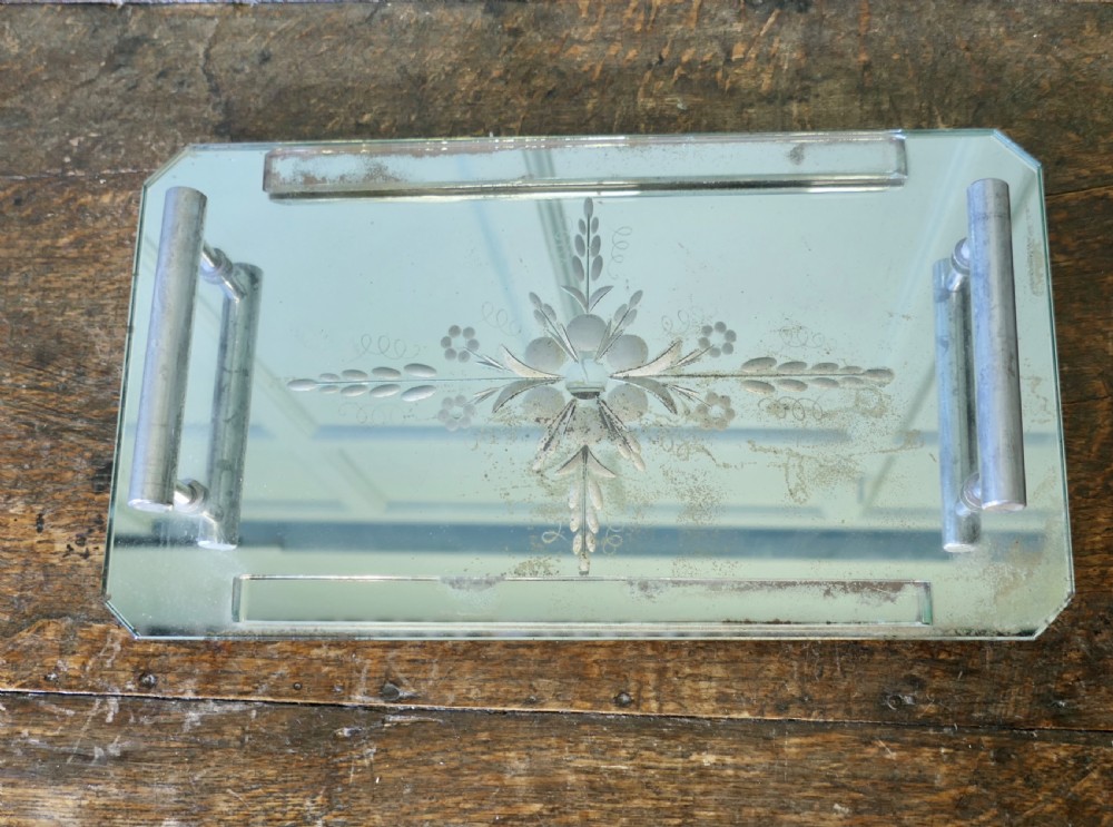 A rectangular Art Deco mirrored tray featuring central etched floral details, cut corners, and tubular silver-tone handles. View IV