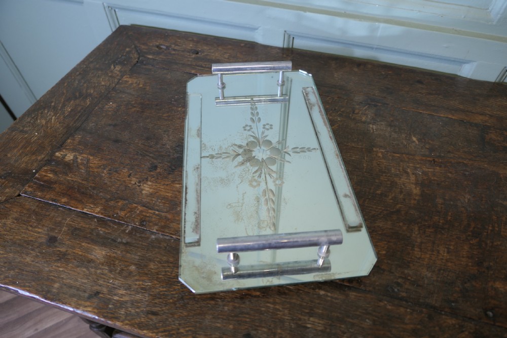 A rectangular Art Deco mirrored tray featuring central etched floral details, cut corners, and tubular silver-tone handles. View V