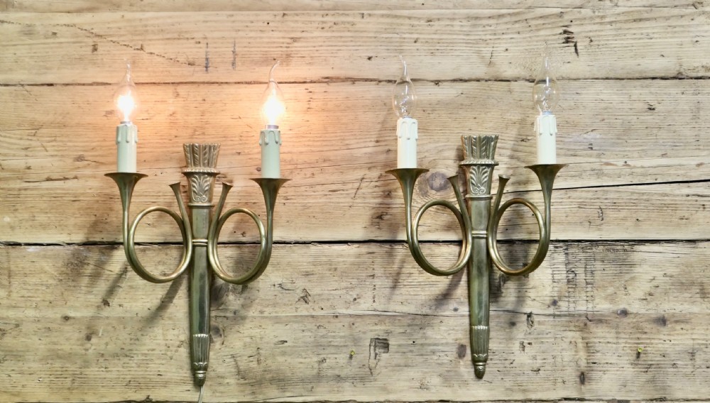 A pair of French Art Deco brass wall sconces formed in the shape of double hunting horns with candle bulb holders. View III