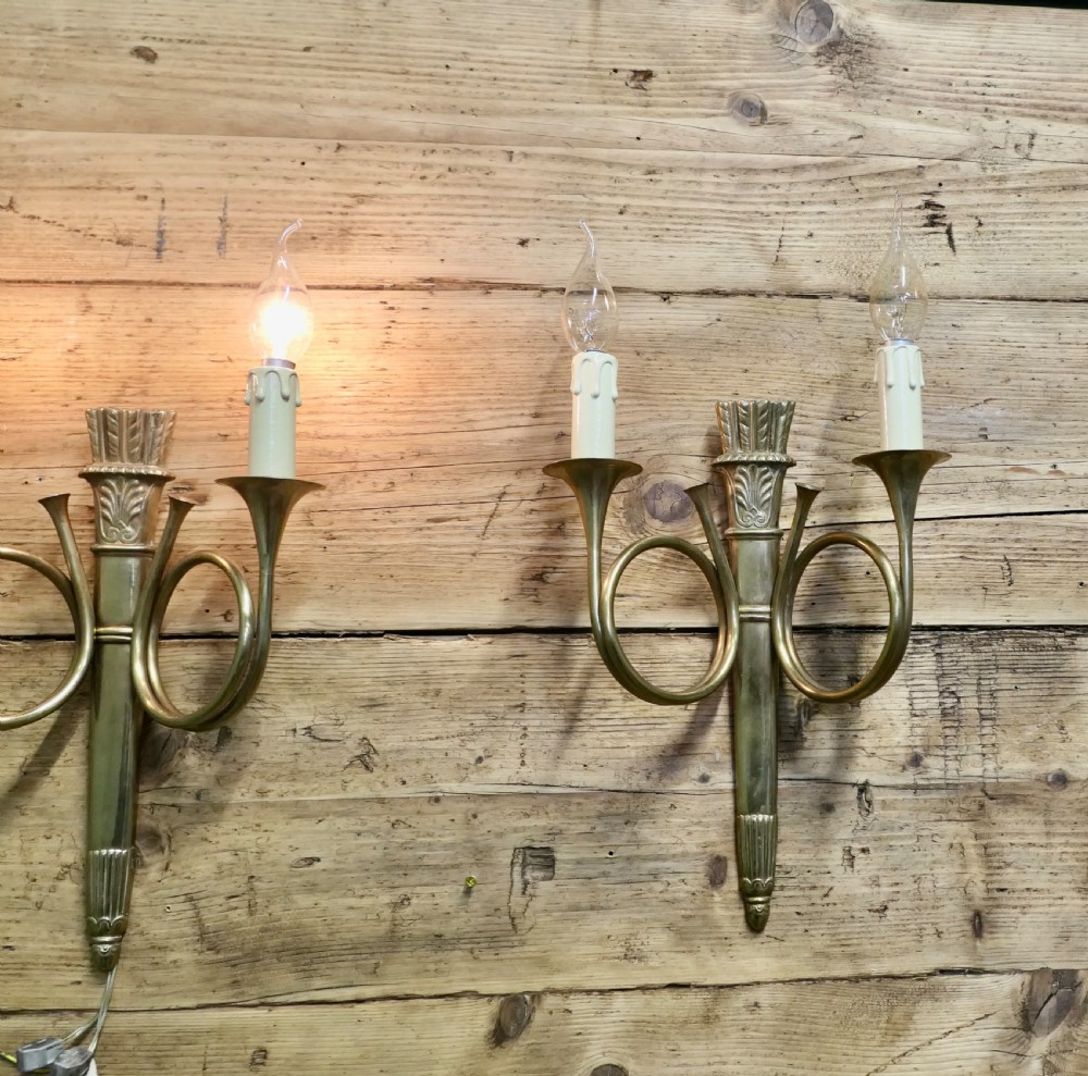 A pair of French Art Deco brass wall sconces formed in the shape of double hunting horns with candle bulb holders. View IV