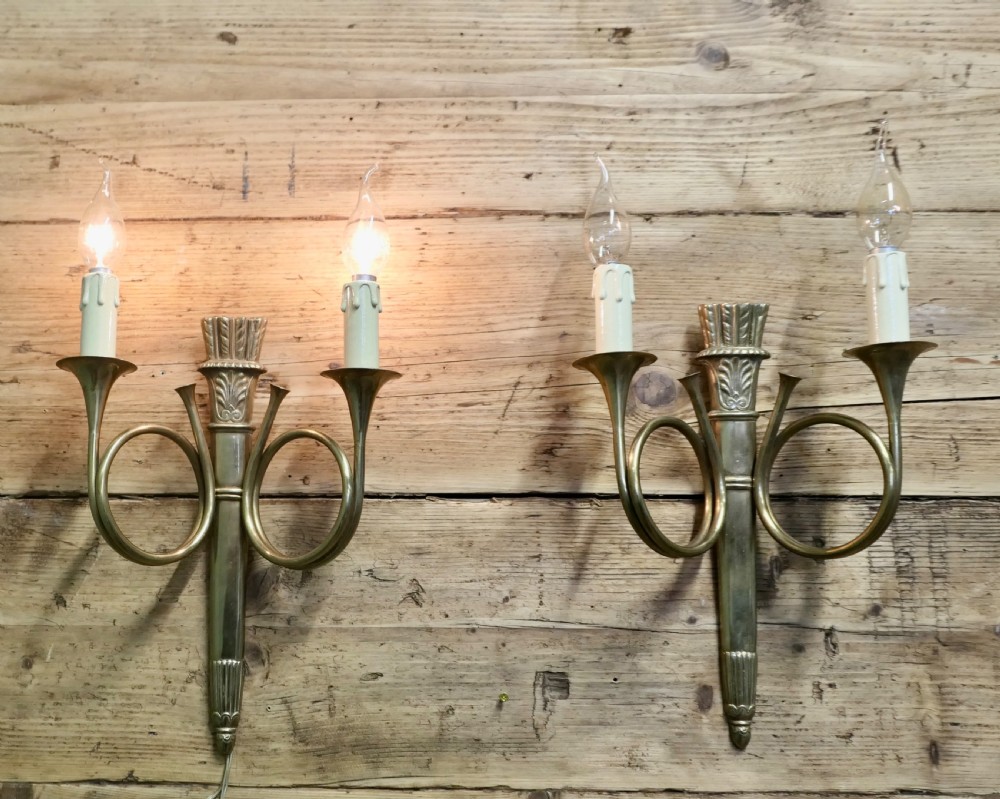 A pair of French Art Deco brass wall sconces formed in the shape of double hunting horns with candle bulb holders. View V