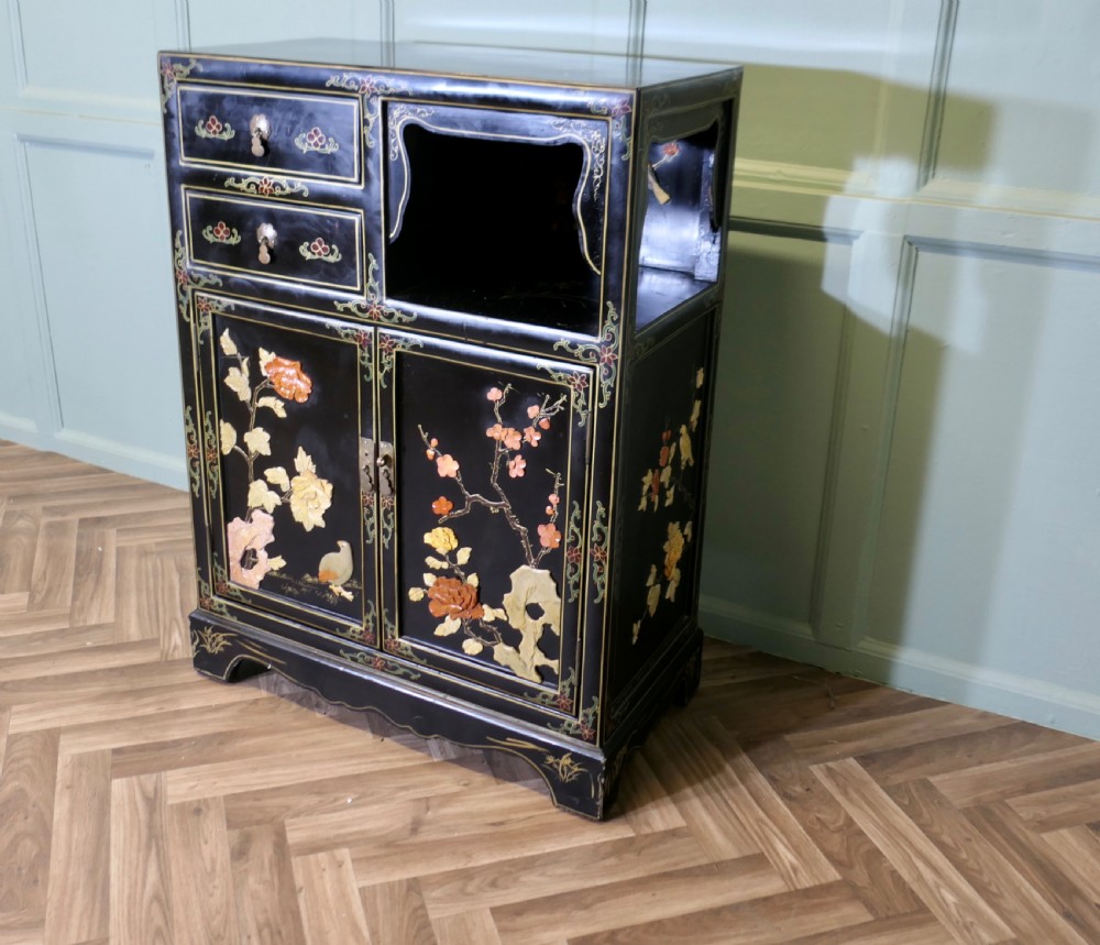 A black lacquered Chinoiserie cupboard featuring two drawers, an open upper display niche, and lower double doors decorated with floral and bird inlays. View II