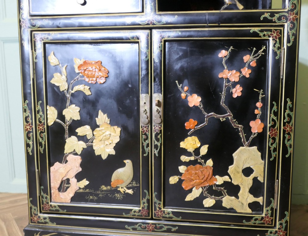 A black lacquered Chinoiserie cupboard featuring two drawers, an open upper display niche, and lower double doors decorated with floral and bird inlays. View VIII