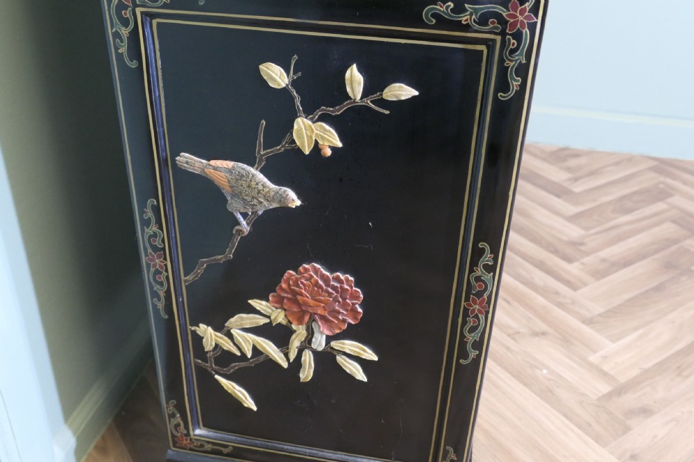 A black lacquered Chinoiserie cupboard featuring two drawers, an open upper display niche, and lower double doors decorated with floral and bird inlays. View IX