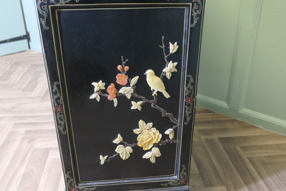 A black lacquered Chinoiserie cupboard featuring two drawers, an open upper display niche, and lower double doors decorated with floral and bird inlays. View X