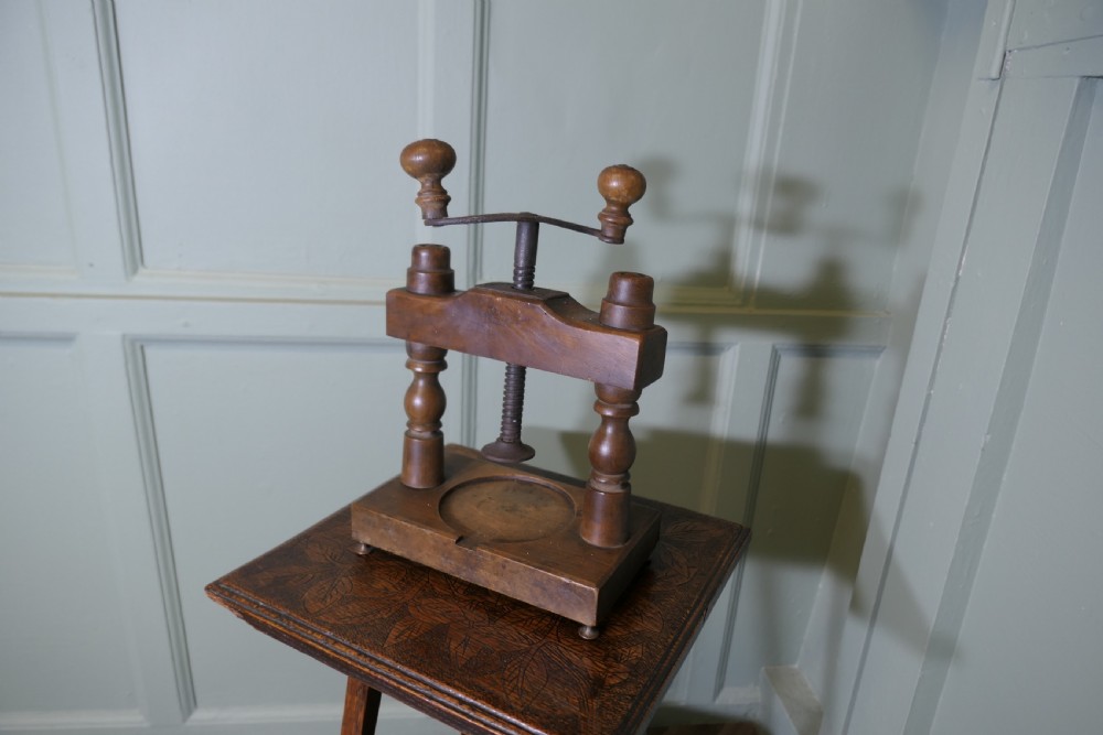 A nineteenth-century French wooden cheese press featuring turned upright columns, a hand-cranked screw mechanism, and a circular recessed base with a drainage channel. View II