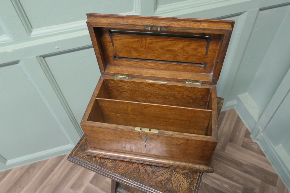 A rectangular golden oak correspondence letter box featuring top slots with metal plaques, a central brass keyhole escutcheon, and a moulded base. View III