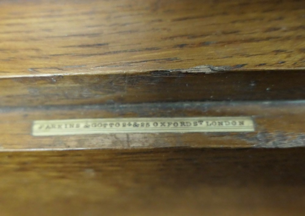 A rectangular golden oak correspondence letter box featuring top slots with metal plaques, a central brass keyhole escutcheon, and a moulded base. View IV