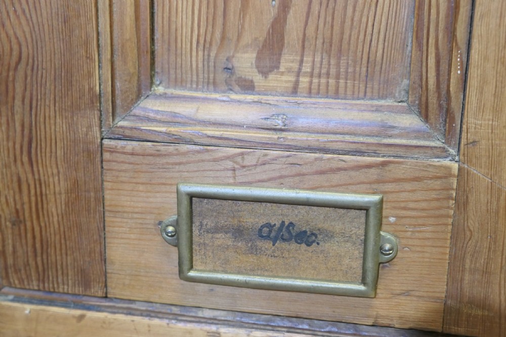 A four-door golden pine sports locker featuring numbered metal tags, circular ventilation holes, and brass fittings. View IX