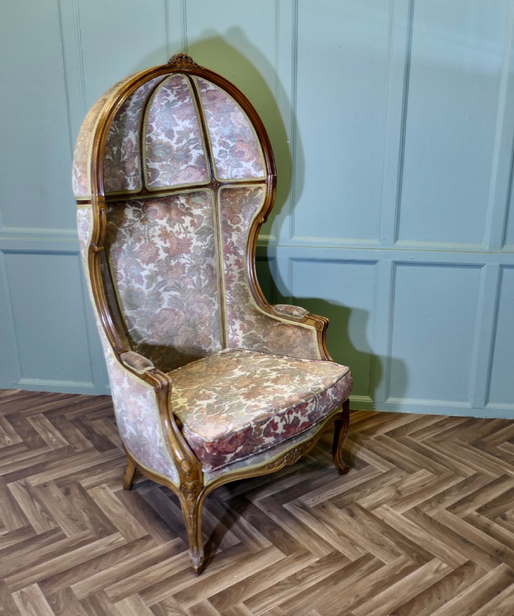 A French Rococo style hooded hall porter chair with a carved timber frame and patterned floral velvet fabric upholstery. View IV