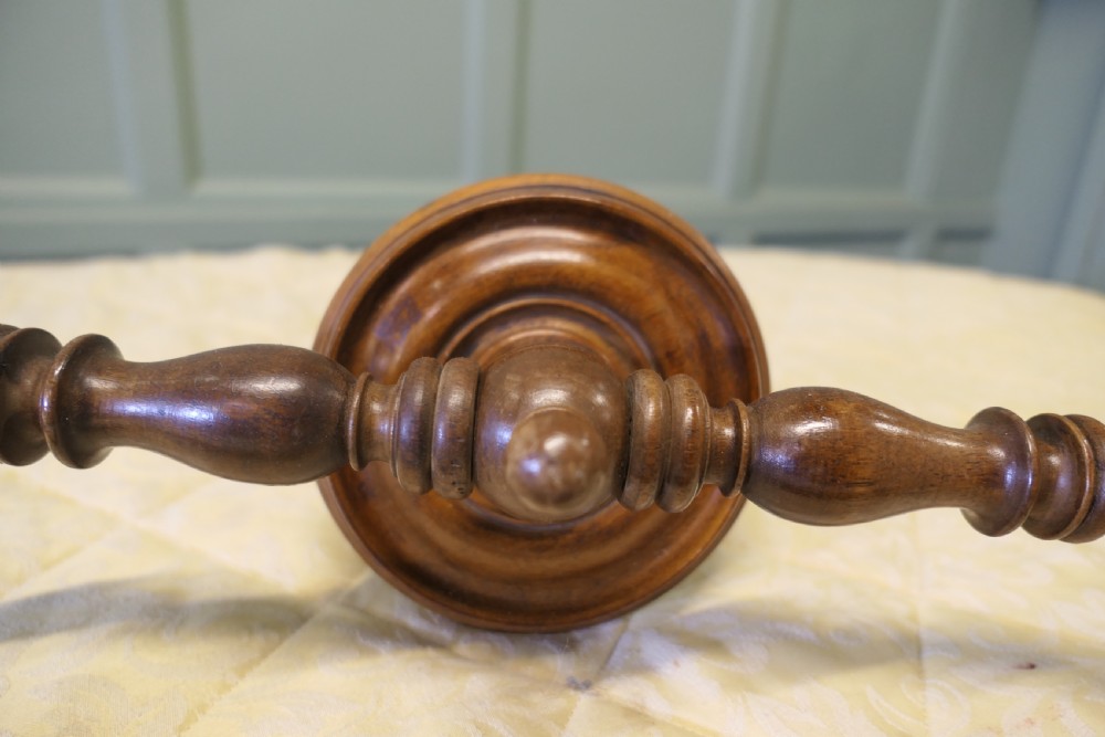 A turned walnut wall-mounted bed canopy frame with a circular backplate and curved drapery hoop. View III
