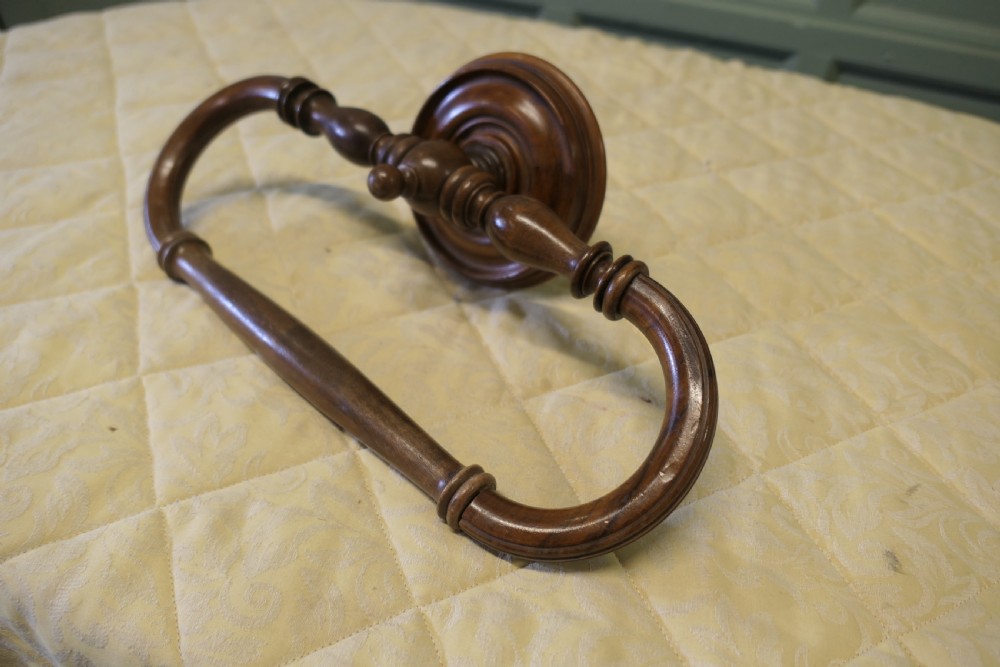 A turned walnut wall-mounted bed canopy frame with a circular backplate and curved drapery hoop. View IV