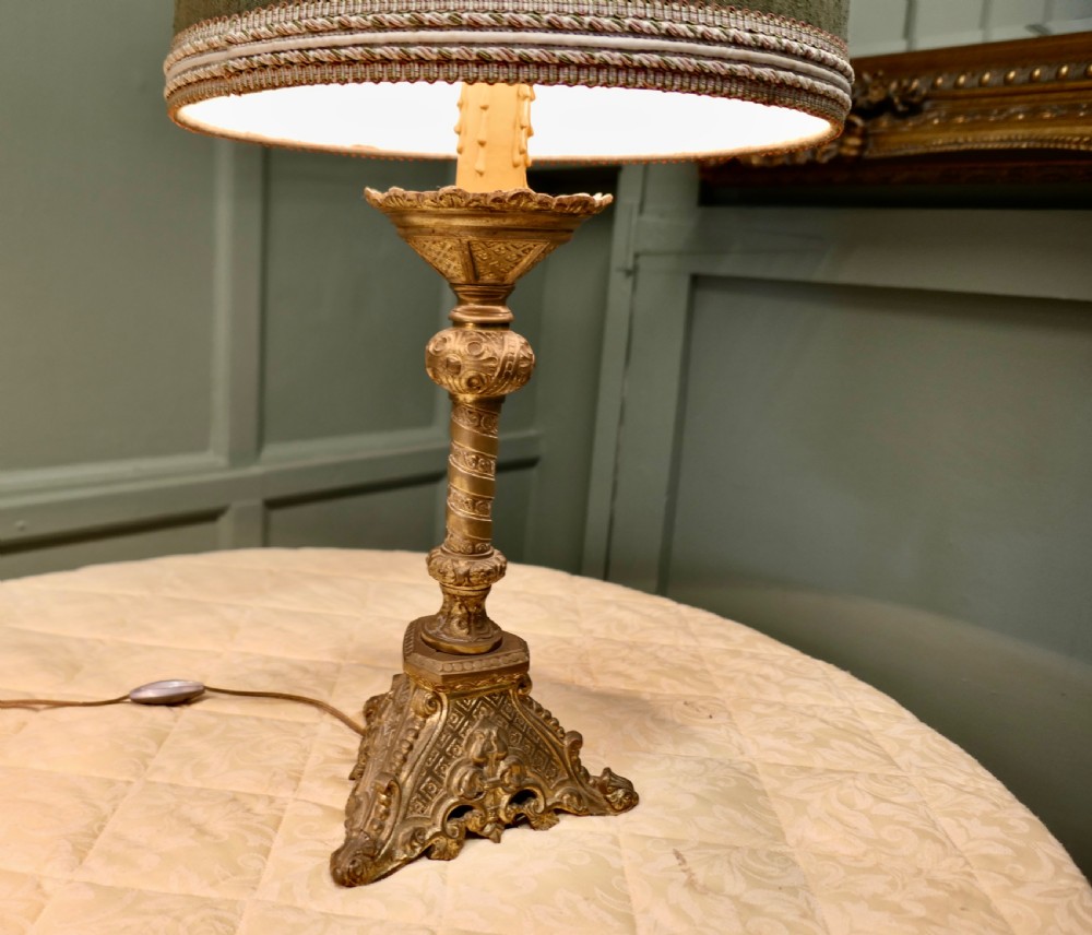 A pair of heavy French Gothic style brass table lamps featuring turned columns, ornate openwork bases, and green fabric shades. View V