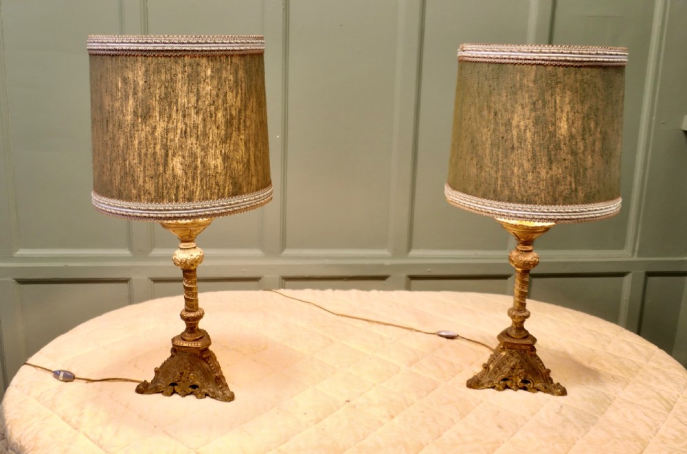 A pair of heavy French Gothic style brass table lamps featuring turned columns, ornate openwork bases, and green fabric shades. View VII
