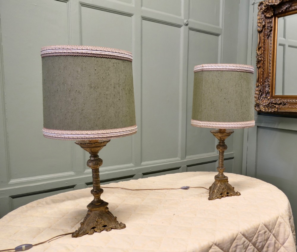 A pair of heavy French Gothic style brass table lamps featuring turned columns, ornate openwork bases, and green fabric shades. View VIII