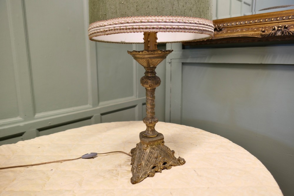 A pair of heavy French Gothic style brass table lamps featuring turned columns, ornate openwork bases, and green fabric shades. View IX
