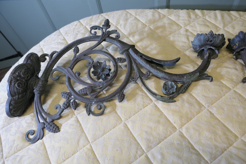 A pair of elaborate dark patinated French bronze wall brackets featuring scrollwork, floral rosettes, and pinecone motifs. View II