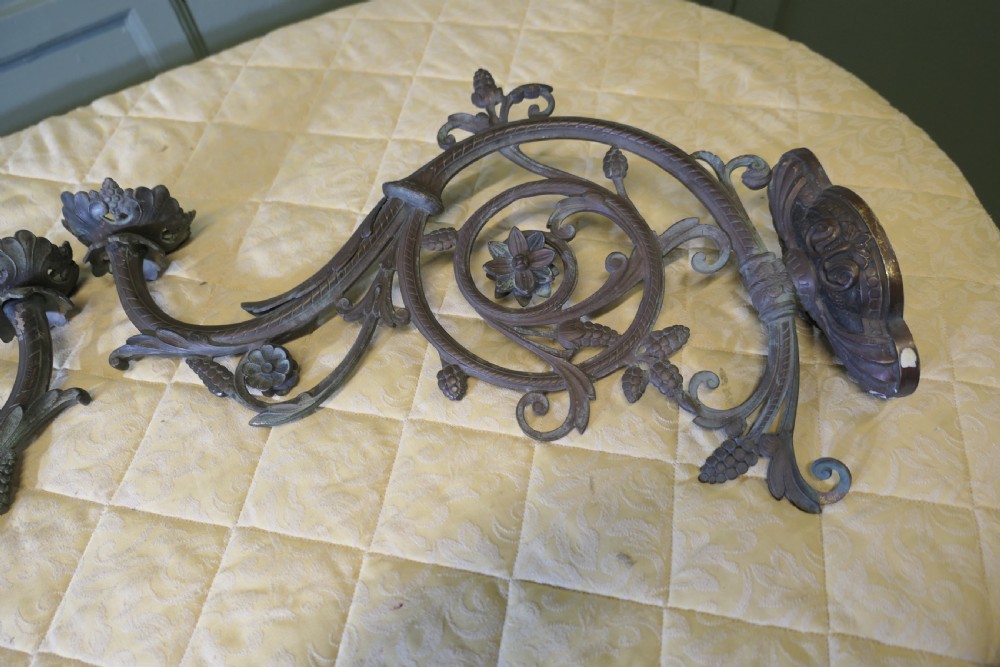 A pair of elaborate dark patinated French bronze wall brackets featuring scrollwork, floral rosettes, and pinecone motifs. View III