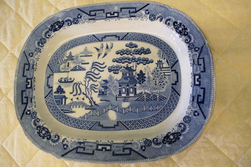 An oval Victorian ironstone meat platter featuring a cobalt blue Willow transferware pattern on a white glazed ceramic ground.