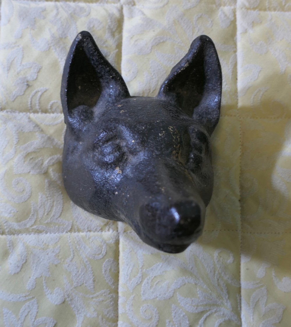 A dark cast iron doorstop sculpted in the shape of a fox head with a flat base. View II