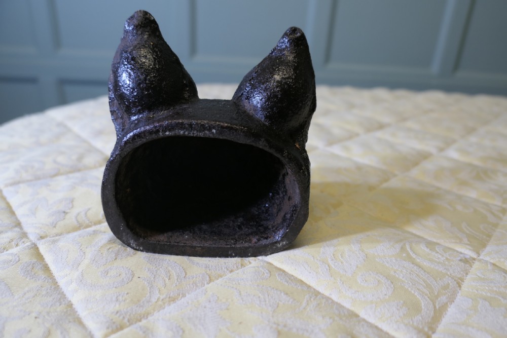 A dark cast iron doorstop sculpted in the shape of a fox head with a flat base. View VI