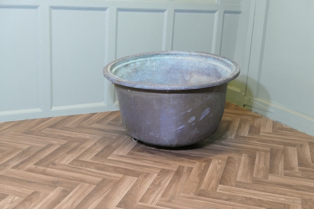 An early 19th-century large copper cauldron with a broad rolled rim and aged patinated surface finish.