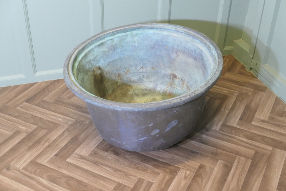 An early 19th-century large copper cauldron with a broad rolled rim and aged patinated surface finish. View II