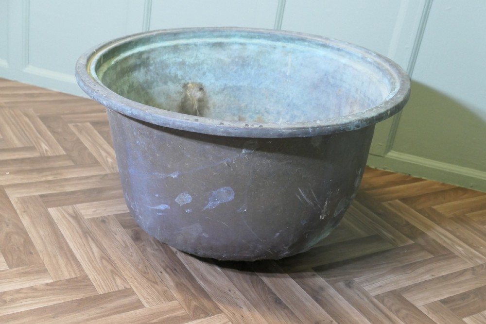 An early 19th-century large copper cauldron with a broad rolled rim and aged patinated surface finish. View III