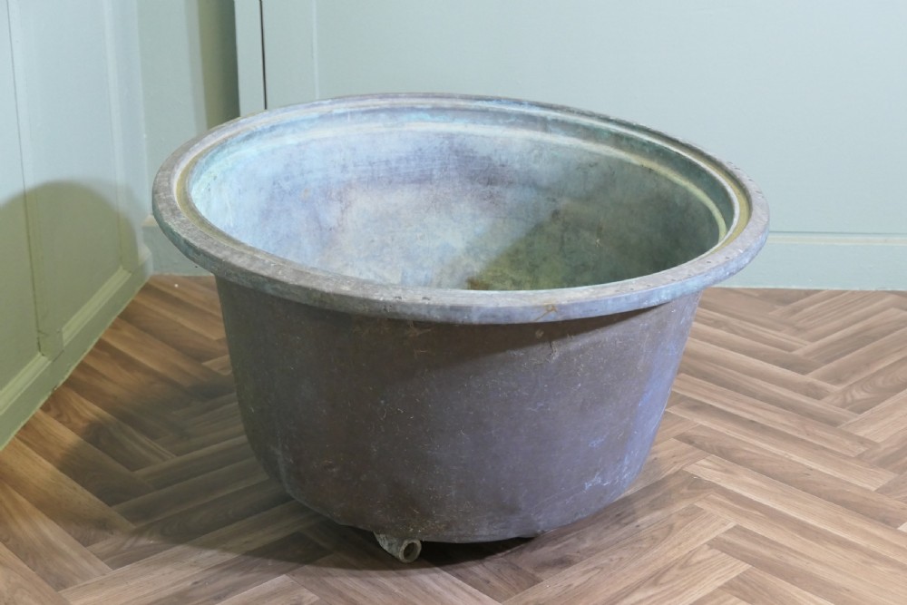 An early 19th-century large copper cauldron with a broad rolled rim and aged patinated surface finish. View V