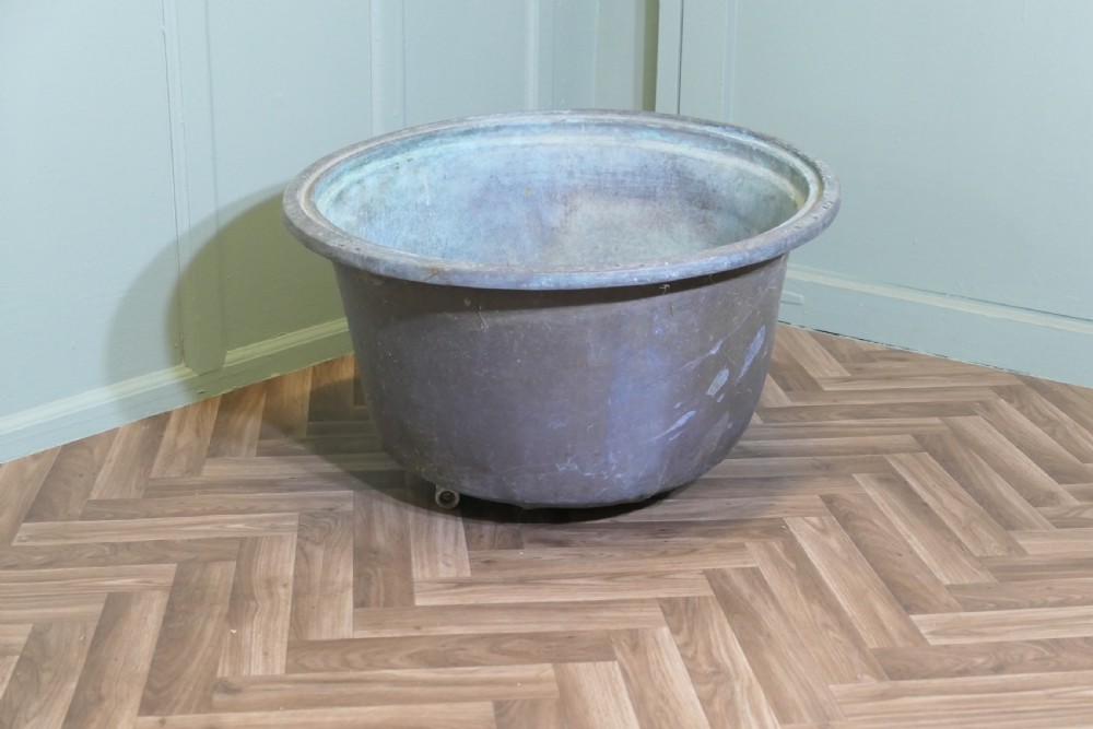 An early 19th-century large copper cauldron with a broad rolled rim and aged patinated surface finish. View VI