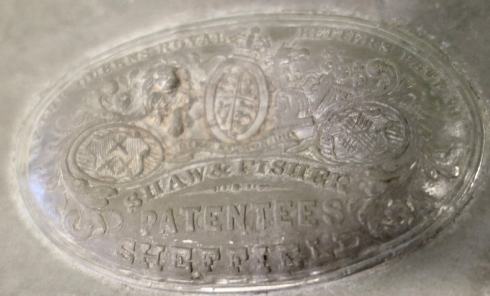 An oval antique pewter meat platter featuring raised tree-like drainage channels leading to a well at one end, flanked by a moulded rim. View II