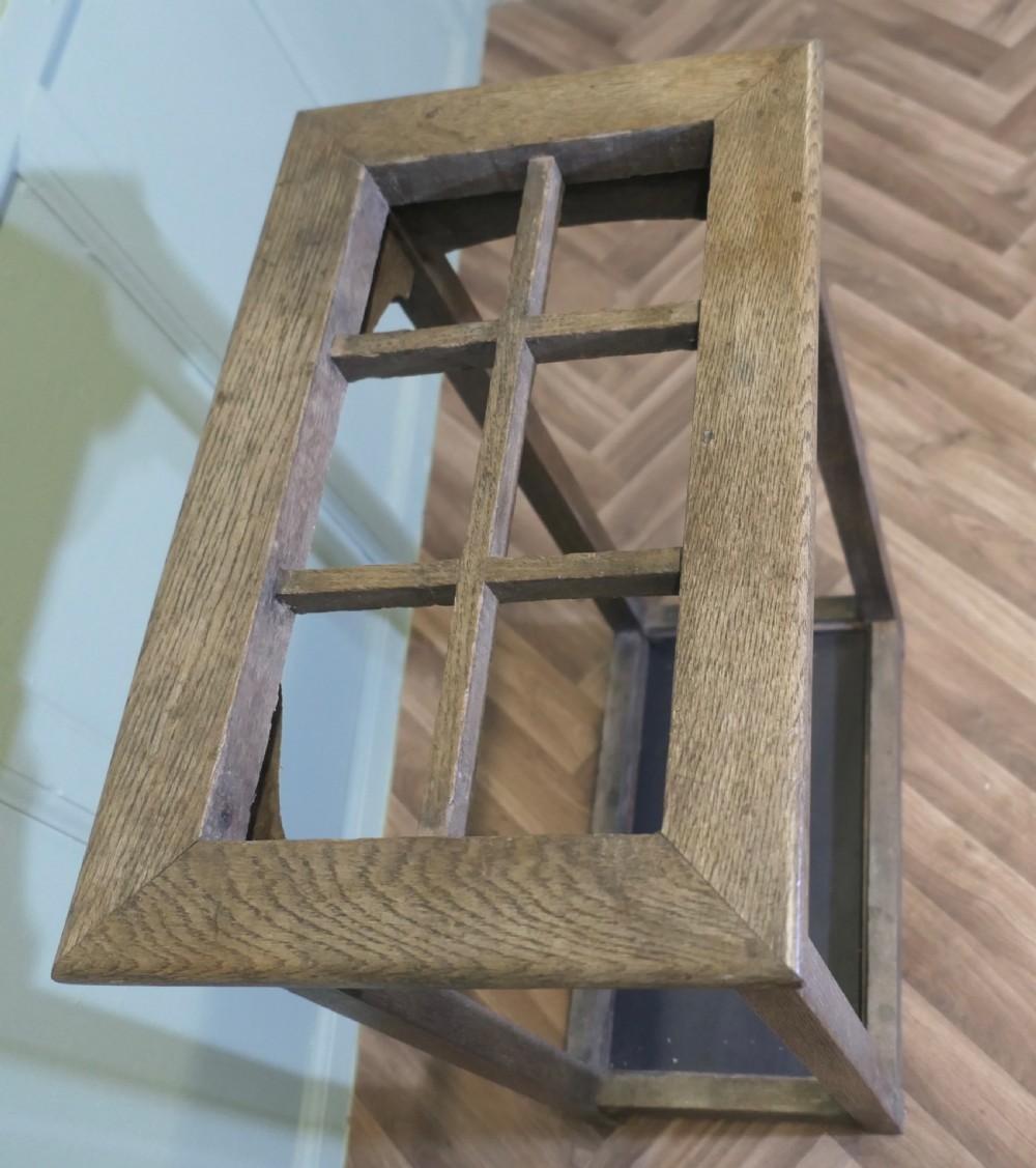 A rectangular Arts and Crafts oak umbrella stand featuring a six-compartment top grid, four square legs with corner brackets, and a dark base tray. View II
