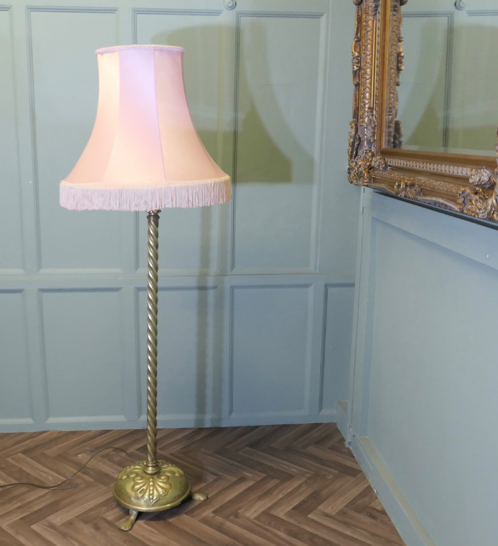 An antique brass floor lamp with a twisted column stem, adjustable height section, and a pink fabric shade with tassel fringe. View II