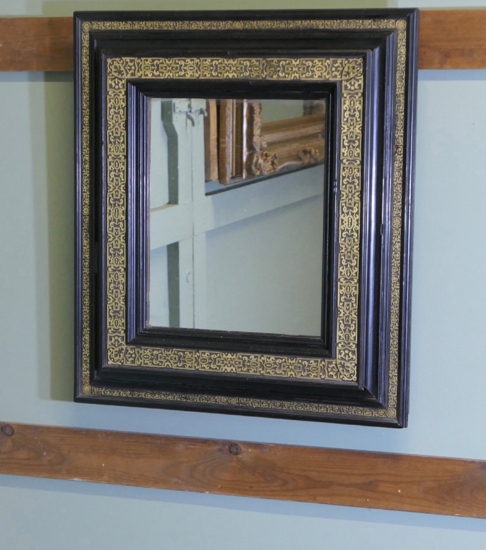 A rectangular black ebonised wall mirror featuring ornate gilt brass chased mounts along its frame. View II