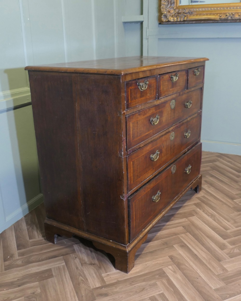 An 18th-century chest of drawers featuring inlaid walnut and satinwood crossbanding with brass drop handles and bracket feet. View II