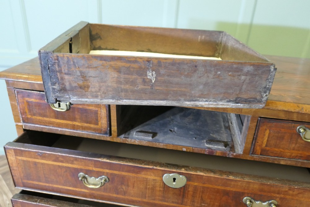 An 18th-century chest of drawers featuring inlaid walnut and satinwood crossbanding with brass drop handles and bracket feet. View VII