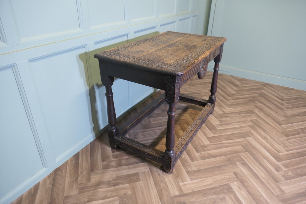 A dark oak rectangular occasional table with hand-carved Celtic knotwork detailing, a relief carved apron, turned legs, and lower stretchers. View III