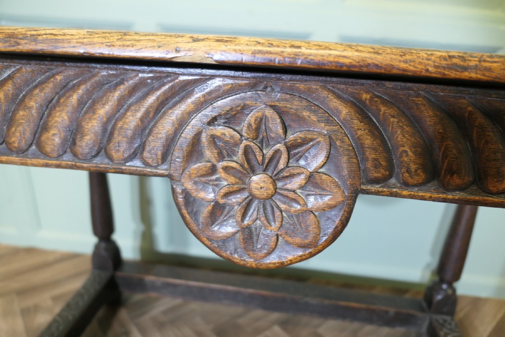 A dark oak rectangular occasional table with hand-carved Celtic knotwork detailing, a relief carved apron, turned legs, and lower stretchers. View V