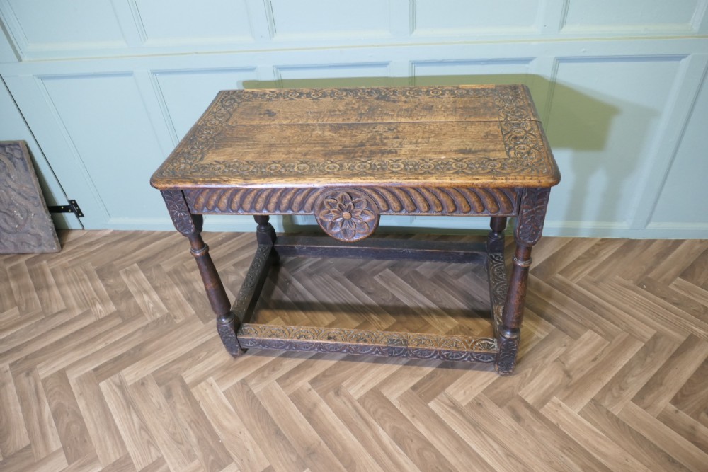 A dark oak rectangular occasional table with hand-carved Celtic knotwork detailing, a relief carved apron, turned legs, and lower stretchers. View VI