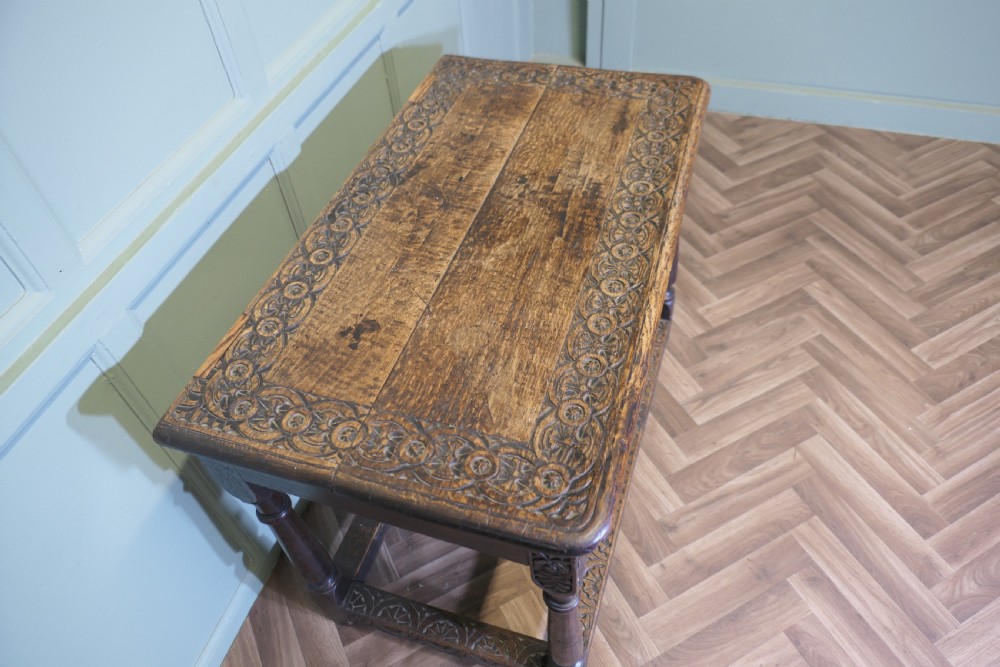 A dark oak rectangular occasional table with hand-carved Celtic knotwork detailing, a relief carved apron, turned legs, and lower stretchers. View VII