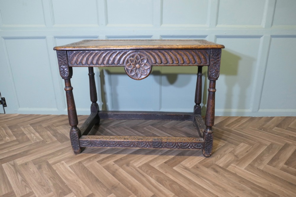 A dark oak rectangular occasional table with hand-carved Celtic knotwork detailing, a relief carved apron, turned legs, and lower stretchers. View VIII