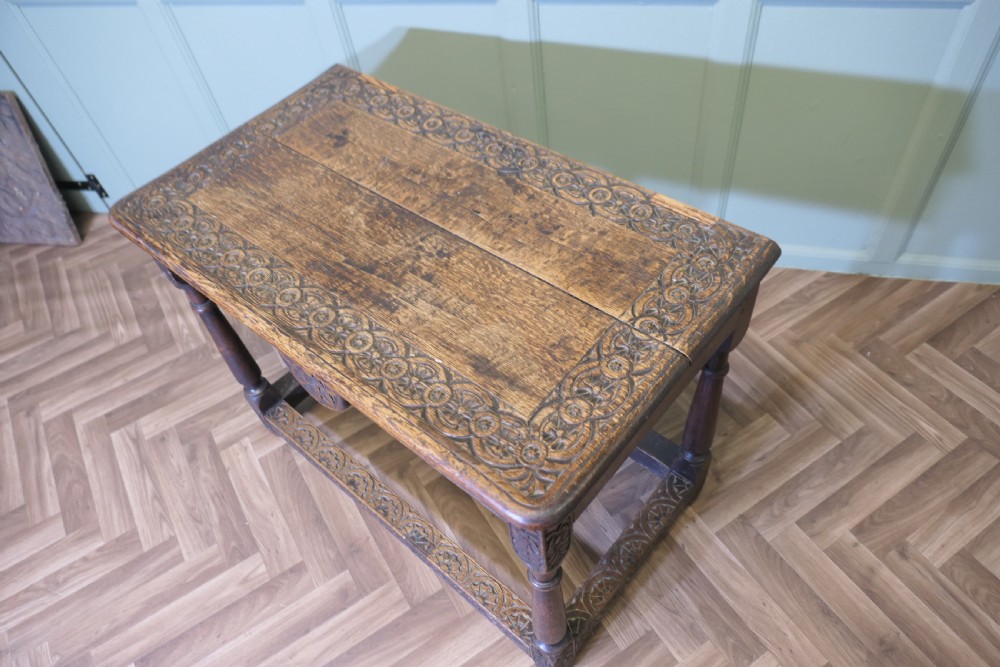 A dark oak rectangular occasional table with hand-carved Celtic knotwork detailing, a relief carved apron, turned legs, and lower stretchers. View IX